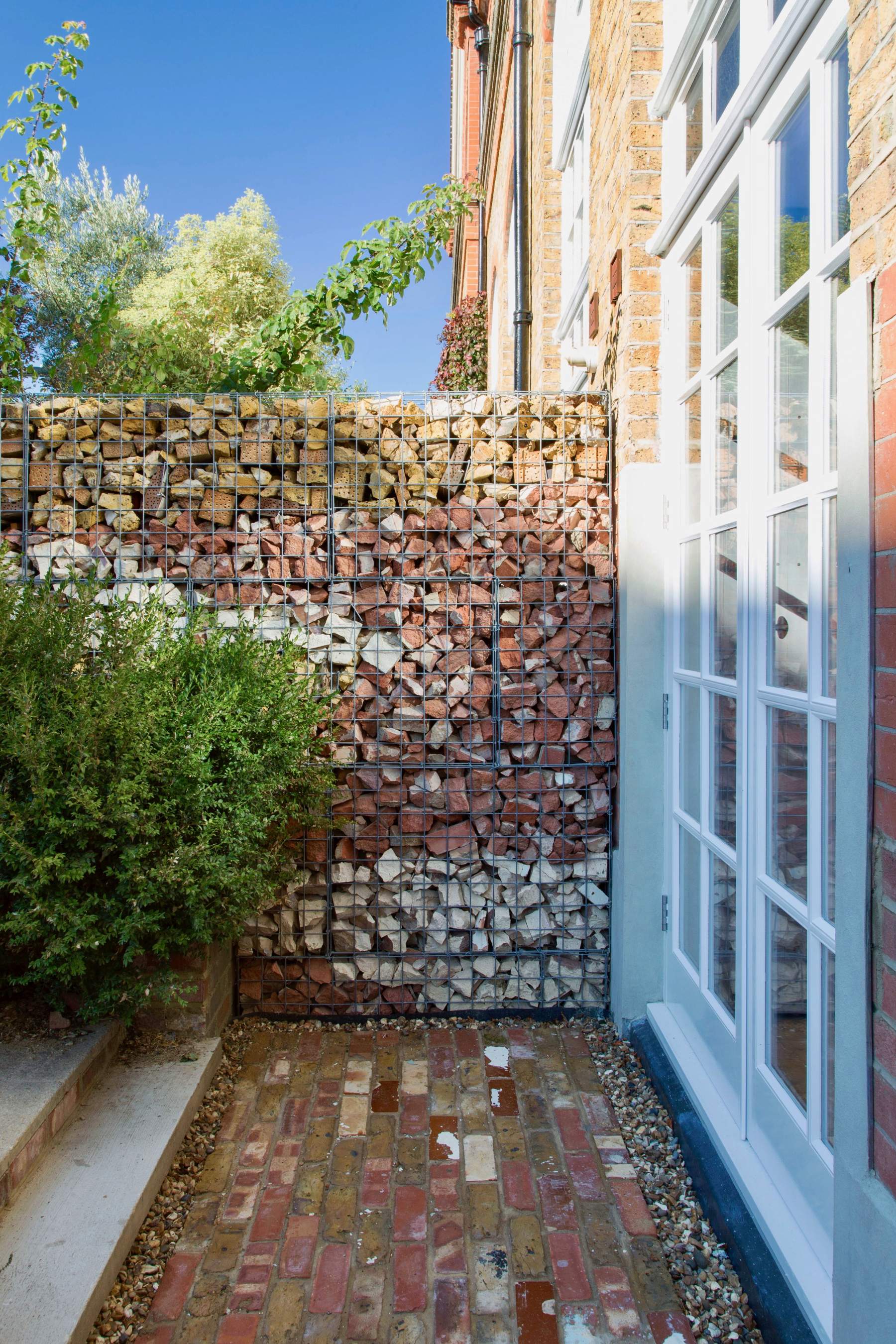 Reclaimed bricks and timber diverted from waste and used in a gabion wall in Reuse Flat.
