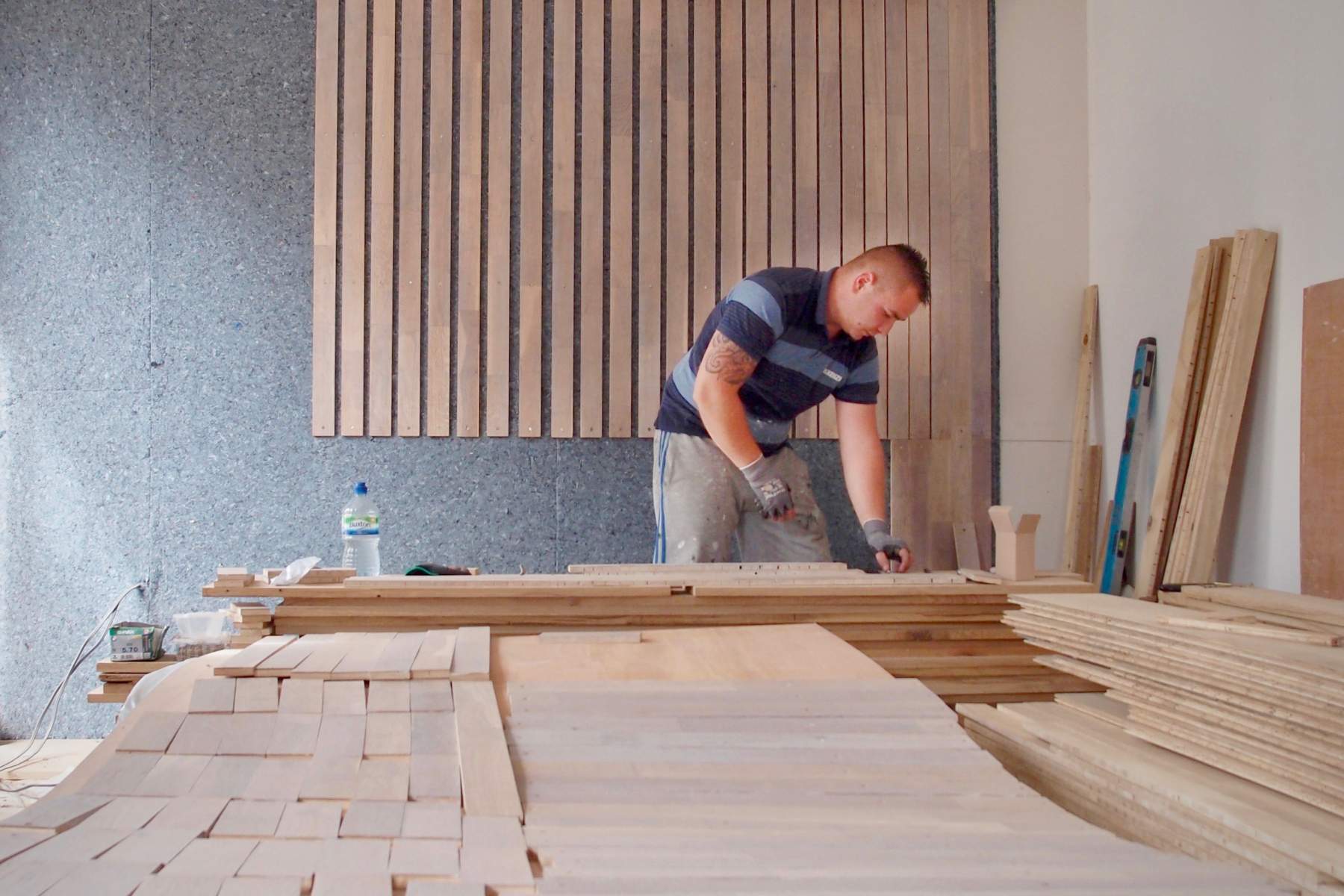 An old floor is reprocessed on site to create a wall lining in Reuse Flat.